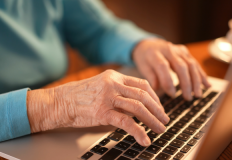 Un'anziana scrive al computer, foto: Adobe Stock