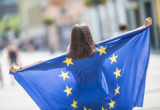 Una ragazza con la bandiera dell'Unione europea. Foto Adobe Stock