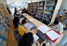 Studenti e studentesse studiano in biblioteca
