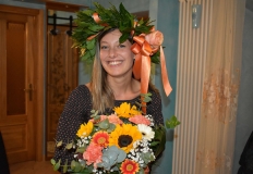 Giulia Arer con la corona di alloro e un mazzo di fiori arancio