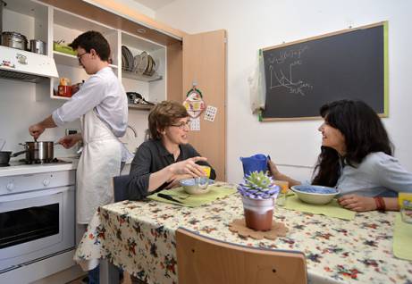 Un ragazzo e due ragazze nella cucina dello Studentato