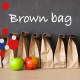 Scritta Brown Bag con sacchetti di carta marroni e due mele