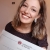 Giulia Arer sorridente che mostra il certificato di laurea